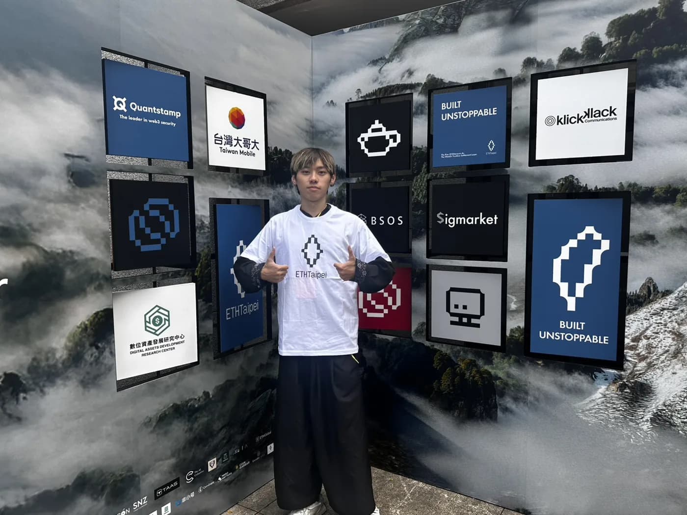 Zuemen Chu in an ETHTaipei shirt in front of the ETHTaipei 2026 sponsor wall